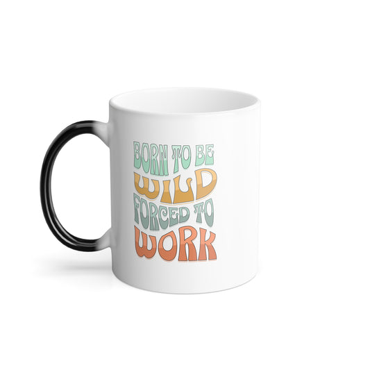 The Printify Color Morphing Mug has a white body, black handle, and features the playful text Born to be wild, forced to work. Perfect for coffee lovers, its heat-sensitive design unveils charm with every warm sip.