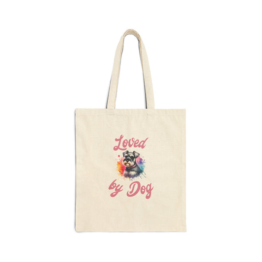 This beige Loved By Dog Fun tote bag by D&B Apparel is crafted from 100% cotton canvas and features Loved by Dog in pink, encircling a cheerful dog with sunglasses on a vibrant splash background.