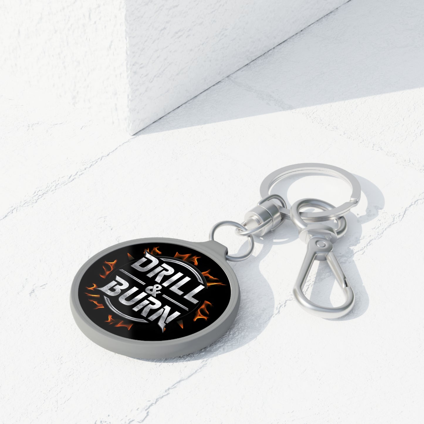 The Drill & Burn Keyring Tag by D&B Apparel is a motivational keychain featuring flame designs and Drill & Burn text on black acrylic. It comes with a clasp and ring, perfect as a unique, personalized gift for car enthusiasts, set against a white surface.