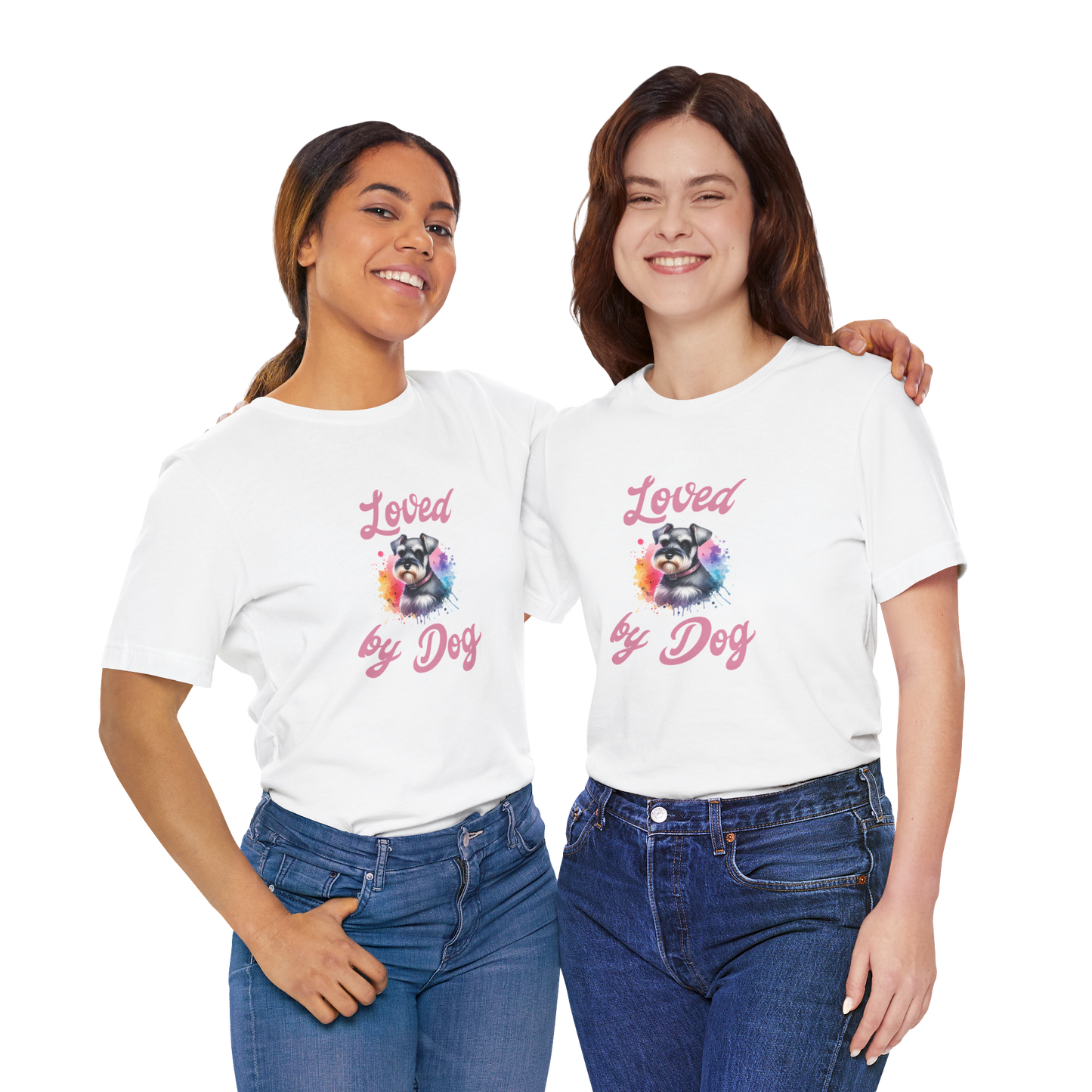 A couple wearing matching white D&B Apparel t-shirts featuring a colorful miniature schnauzer and the phrase Loved by Dog. They smile warmly, with their arms around each other against a plain background.