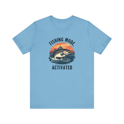 Enjoy comfort and style with Printifys Fishing Mode Activated Tee for Anglers. This blue unisex jersey short sleeve t-shirt, made from Airlume cotton, features a fish leaping against a sunset with Fishing Mode Activated text. Ideal for fishing enthusiasts.
