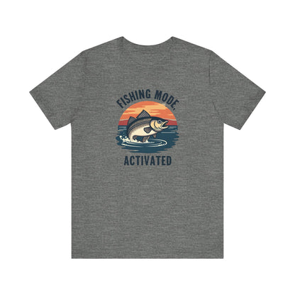 This unisex jersey short-sleeve tee from Printify is crafted from premium Airlume cotton and features a gray design of a fish leaping against a sunset, perfectly capturing the Fishing Mode Activated vibe—a must-have for outdoor enthusiasts.