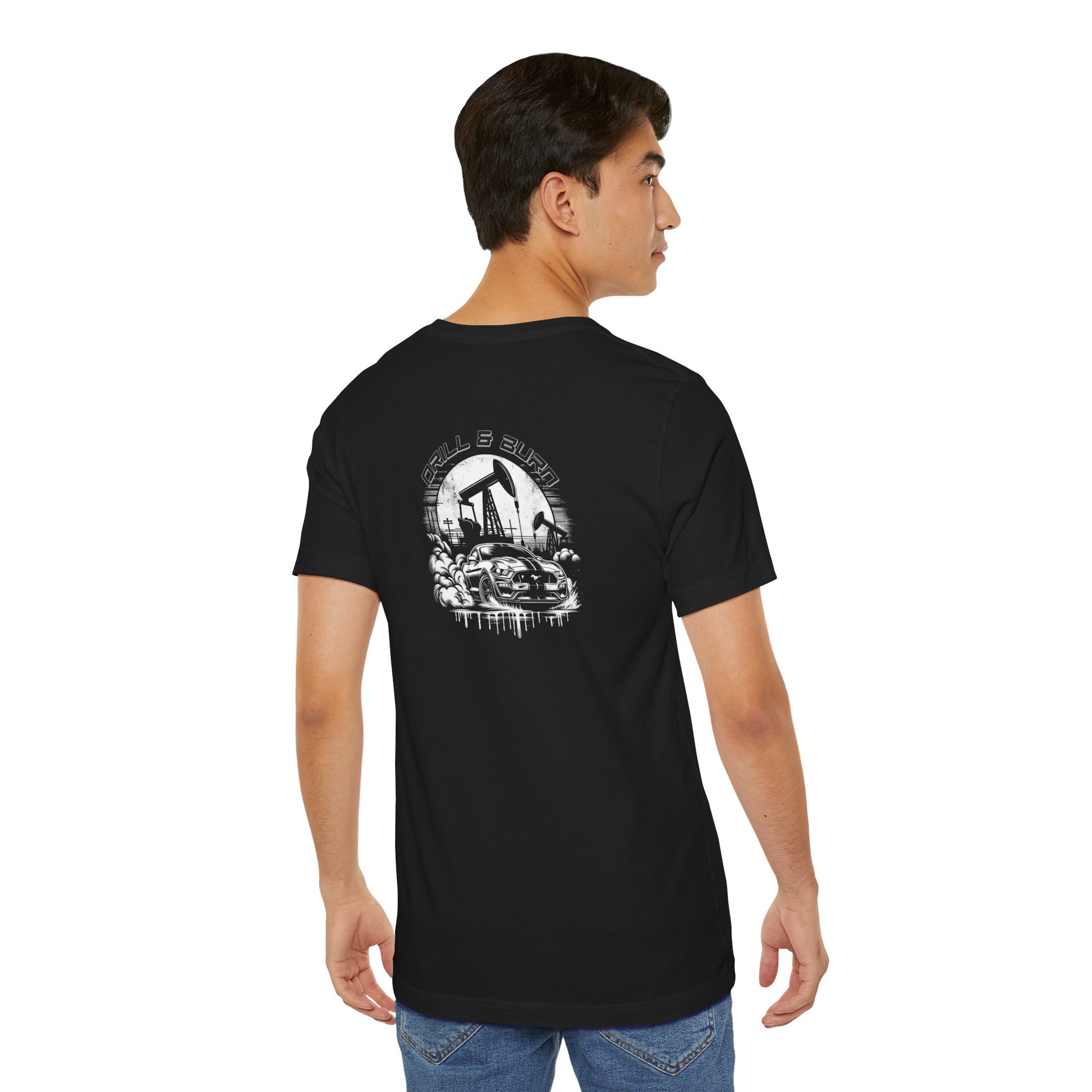 Black Drill & Burn Graphic Unisex Jersey Tee is shown from the back, highlighting an oil drilling scene with a Mustang doing a burnout. 