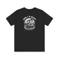 Black Drill & Burn Graphic Unisex Jersey Tee is shown from the front, highlighting an oil drilling scene with a Dodge Challenger doing a burnout. 